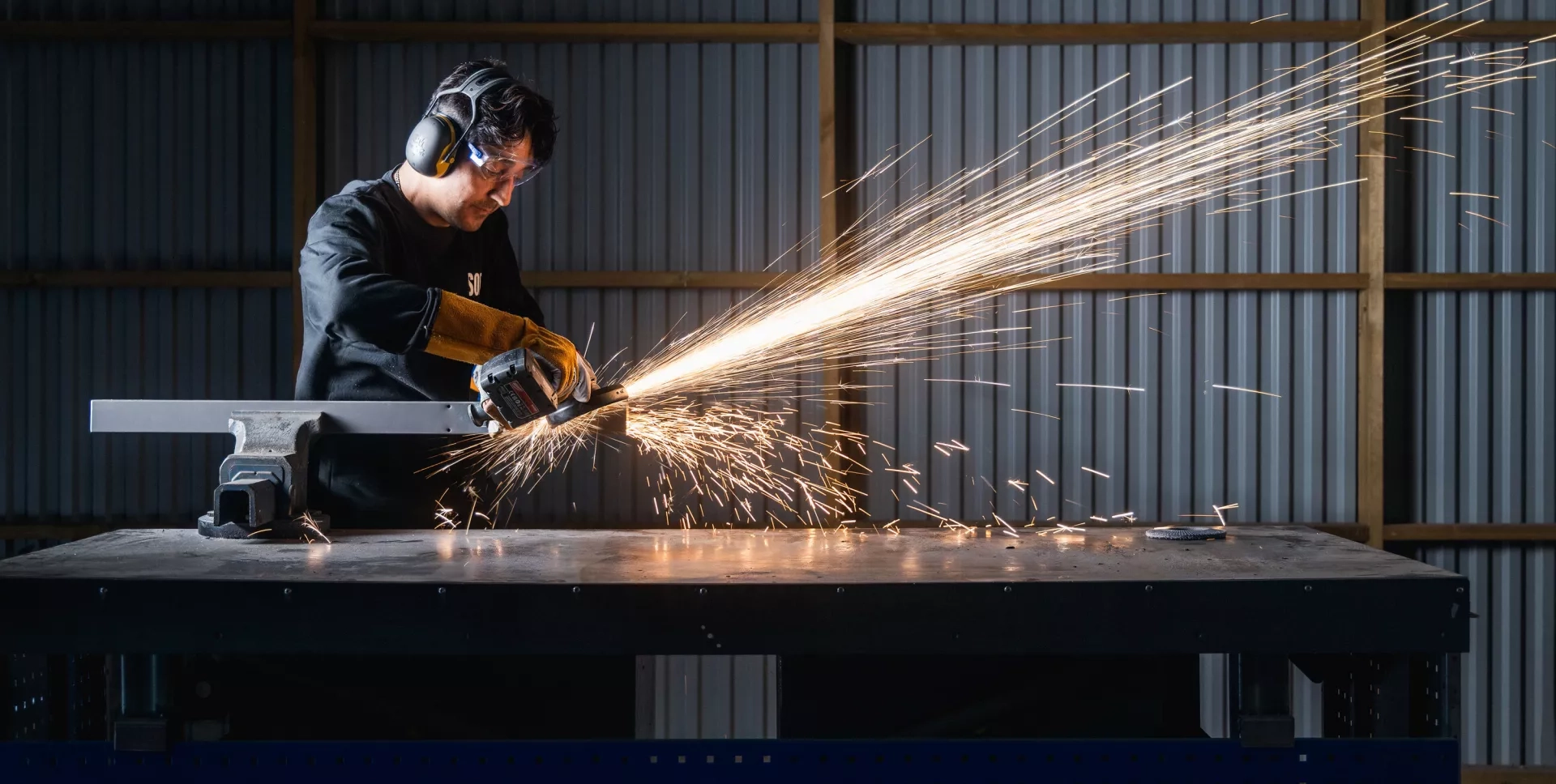 Metallarbetare sågar isär en stomme för ett specialbyggt skrivbord