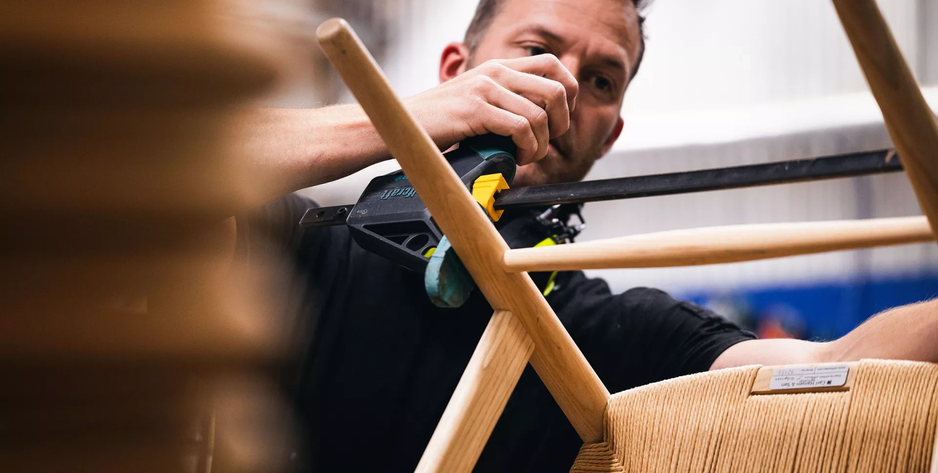 Snickare på Yllw Factory limmar fast ett stag på en Y-stol