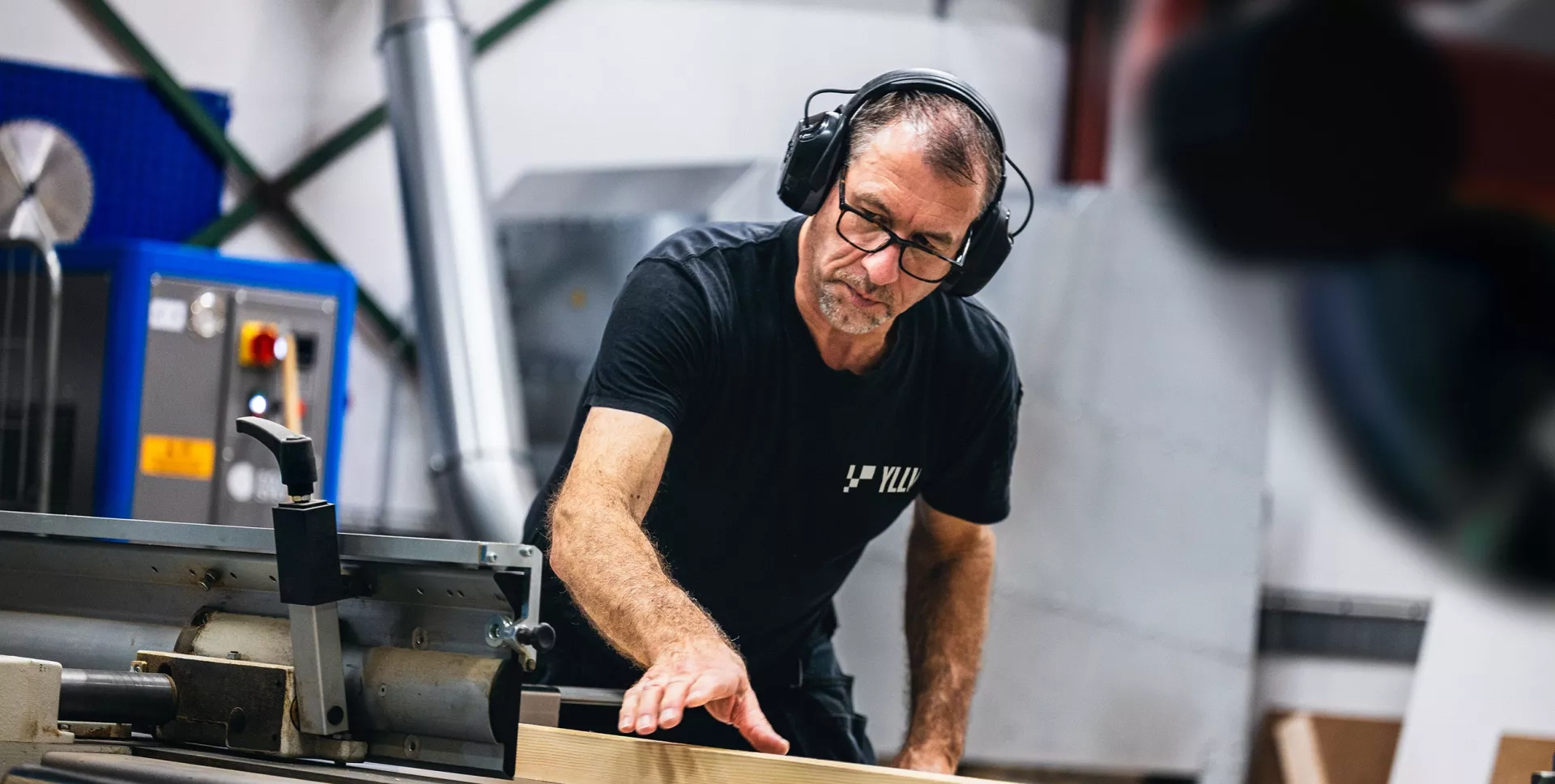Möbelsnickare vid hyvelmaskinen i snickeriet