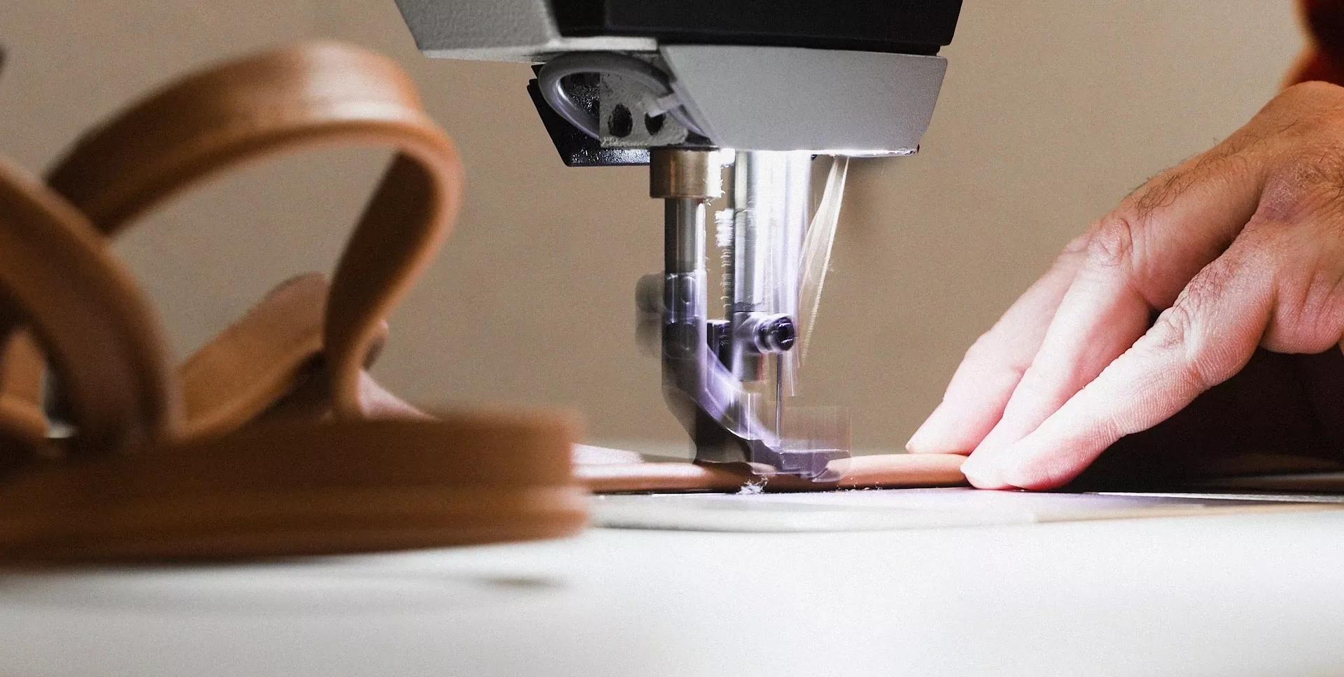 Tapetserare syr piping i läder till en fåtölj